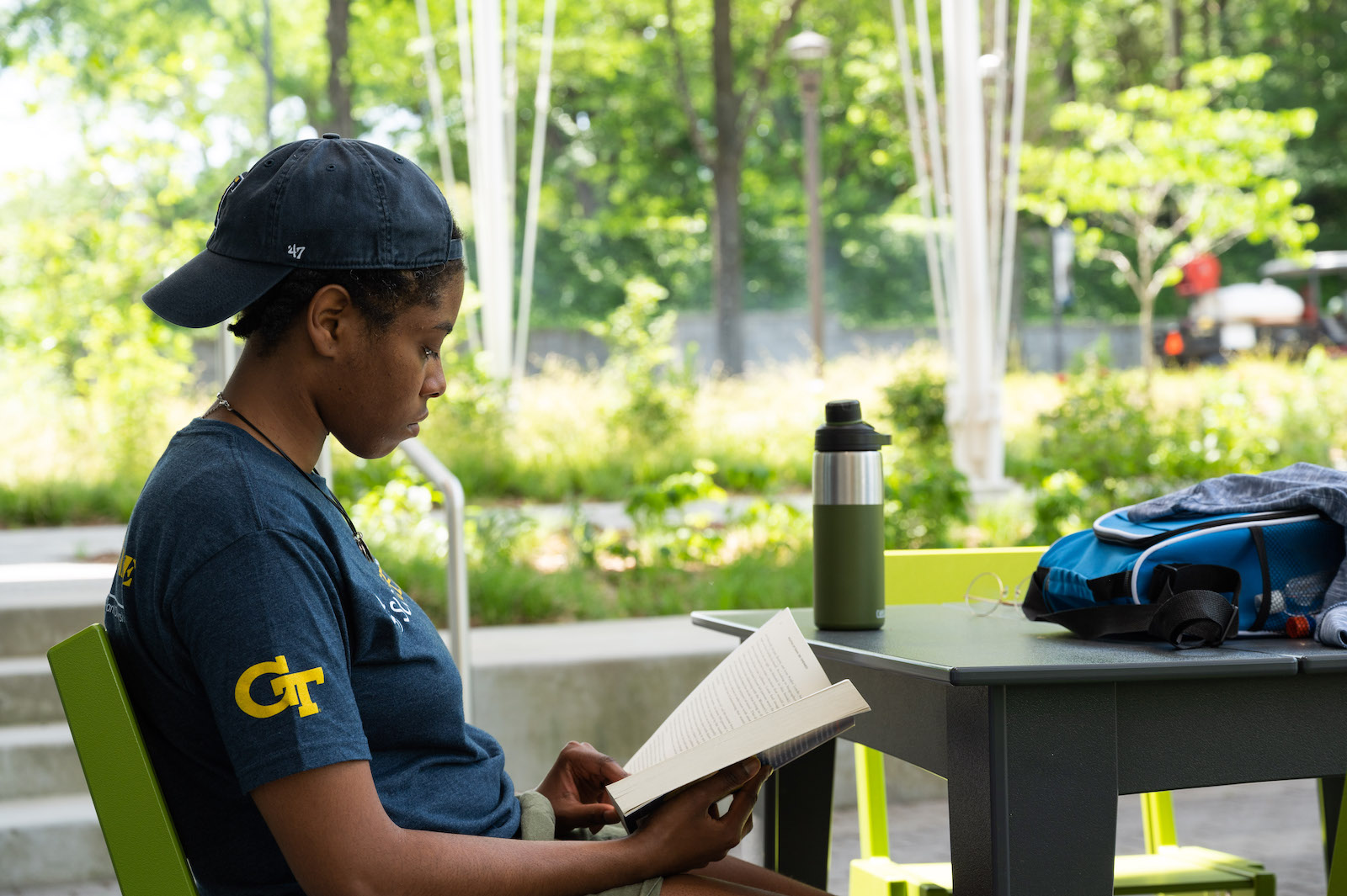 Woman reading a book outside The Kendeda Building. 
