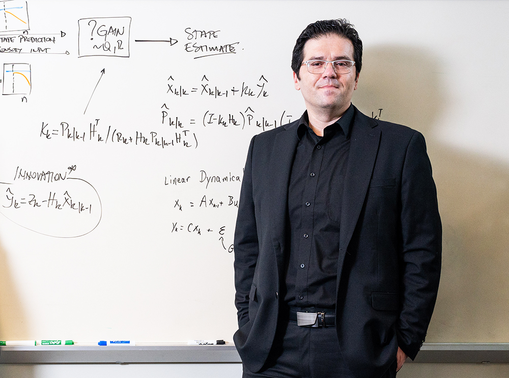 Tansu Celikel standing in front of dry erase board