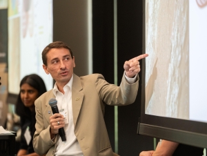 Professor James Wray, professor in the School of Earth and Atmospheric Sciences Professor James Wray holds microphone and points to powerpoint slide during his presentation