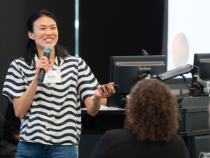Joyce Shi Sim, assistant professor in the School of Earth and Atmospheric Sciences Joyce Shi Sim holds a microphone and laser pointer while presenting to room of people