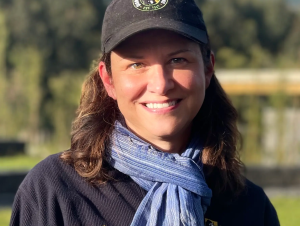 Tara Stoinksi Headshot of a woman wearing a Dian Fossey gorilla fund ball cap